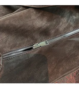 Macro view of smooth silver metal zipper and fine dark brown leather texture on tote bag