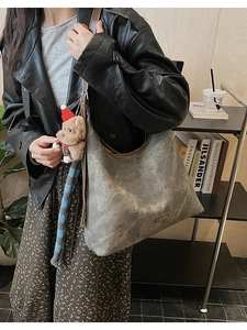 Detail of taupe marble-textured tote bag with leather straps and bear charm