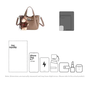 Détail du sac seau en cuir grainé marron montrant la capacité et un charm d'ours