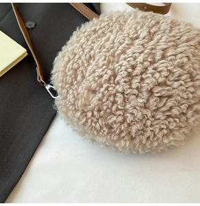 Détail du petit sac rond en peluche beige avec bandoulière en cuir et boucle argentée