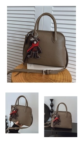Detail view of brown shell bag with pebble leather texture and cute bear charm