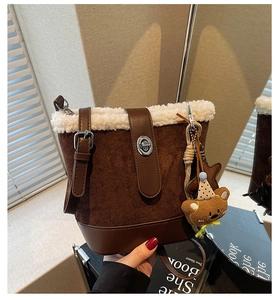 Detail der braunen Wildleder-Beuteltasche mit weißem Kunstpelz und Bärenanhänger