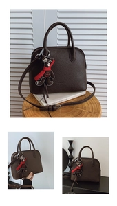 Detail of dark brown litchi pattern shell bag with a cute teddy bear charm
