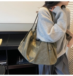 Detail of olive green suede tote bag with daisy floral print and slender strap