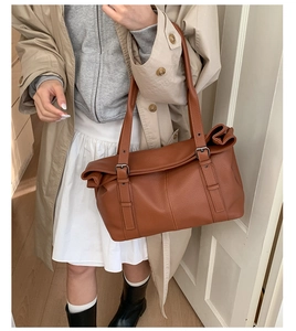 Caramel brown pebbled leather tote bag shown with an elegant beige trench coat