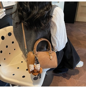 Brown Boston bag with textured leather, adjustable strap and cute bear charm detail