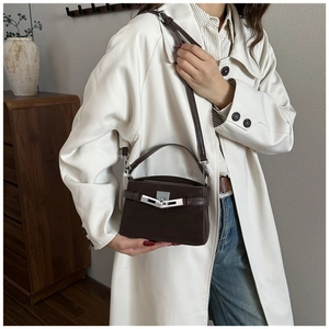 Detail of a dark brown leather handbag with silver twist lock and slim shoulder strap