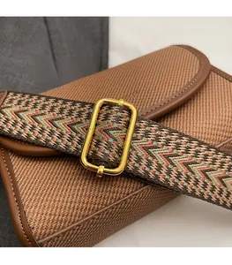 Détail de la bandoulière tissée rétro avec une boucle de réglage en métal doré brillant