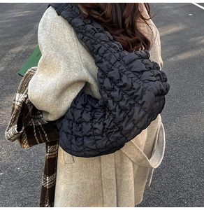 Photo en extérieur du grand sac à bandoulière matelassé noir avec texture plissée