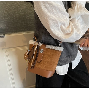 Details einer Winter-Beuteltasche mit weißem Pelzbesatz und süßem Bären-Anhänger