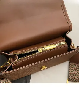 Détail de l'intérieur en cuir grainé marron foncé avec fermeture éclair dorée