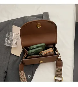 Détail de l'intérieur spacieux du sac à bandoulière marron avec sangle tissée
