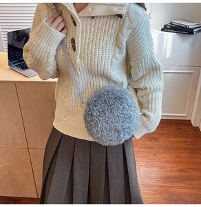 Détail du sac bandoulière rond en peluche grise avec texture en fausse fourrure et lanière