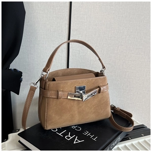 Detail of a brown leather handbag featuring silver metal hardware and a secure turn-lock