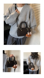 Detail view of brown Boston bag with embossed logo and cute plush bear charm accessory