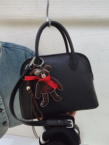 Elegant black lychee leather shell bag with a cute bear pendant and long shoulder strap