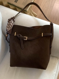 Retro dark brown suede bucket bag with gold buckle and floral silk scarf on sofa