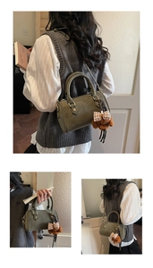 Olive green Boston bag featuring teddy bear pendant and textured faux leather finish