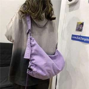 Minimalist purple canvas crossbody bag with drawstring design and wide strap for casual wear