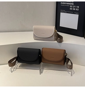Détail de petits sacs bandoulière avec sangles jacquard en crème, noir et marron