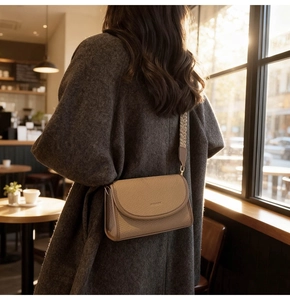 Détail d'un sac bandoulière beige à motif tissé avec bandoulière jacquard sur mannequin