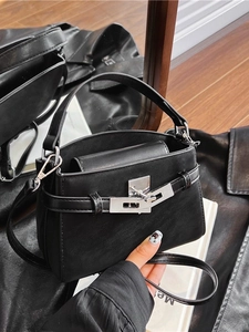 Fashionable black leather handbag with silver turn-lock and crossbody strap design