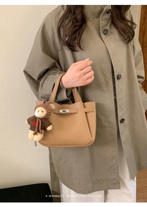 Détail du sac seau en cuir marron avec fermoir métallique et breloque ourson