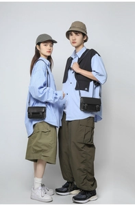 Detailed view of black leather messenger bags styled with unisex utility fashion outfits
