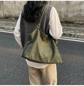 Close-up of olive green tote bag featuring drawstring design and daisy print decoration