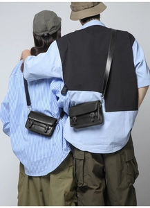 Rear view of models wearing black minimalist crossbody square bags with metal buckles