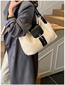 Close-up of white plush faux fur bag with black leather straps and metal buckle detail