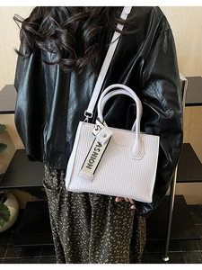 Detail of white PU leather crossbody bag with vertical textures and fashion strap