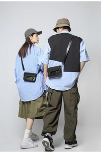 Detail of a minimalist black leather messenger bag with classic double buckle closure