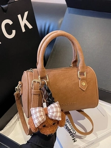 Elegant brown pebble leather Boston bag with teddy charm and adjustable strap