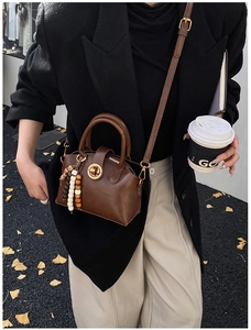 Deep brown shell-shaped crossbody bag styled with autumn street fashion outfit