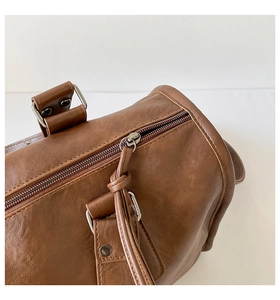 Detail shot of brown leather pillow bag with silver zipper and knot puller