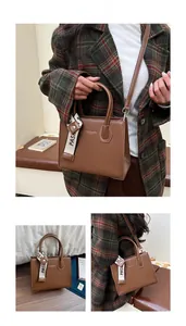 Detail of a vintage brown crossbody bag with vertical grain leather and fashion ribbon