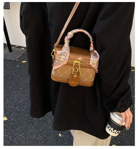 Detail of vintage box bag with brown patchwork leather and silk scarf handle accent