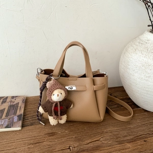 Détail du sac seau en cuir grainé kaki avec fermoir argenté et breloque ours mignon
