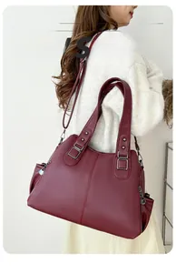 Macro detail of wine red pebbled leather tote bag with silver metal hardware and stitching