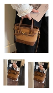 Close-up of retro brown bucket bag with suede panels and gold-tone horsebit detail