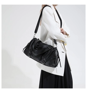 Close-up of black retro motorcycle bag showing soft leather texture and zipper details
