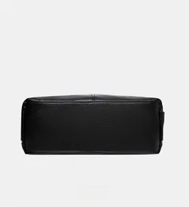 Close-up of the rectangular base and reinforced stitching on black lychee leather tote bag