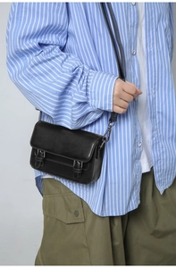 Detailed view of a black retro small square crossbody bag with double buckle straps