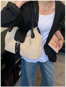 Detail of soft cream faux fur tote bag with black leather straps and silver buckle clasp