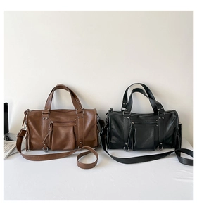 Side-by-side view of black and brown Boston bags with textured leather and metal hardware