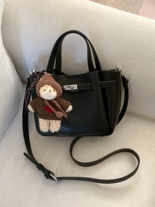 Sac seau noir minimaliste en cuir grainé avec un petit ours en peluche et bandoulière