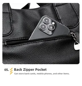 Detail of the back zipper pocket on the black pebble leather tote bag for secure storage
