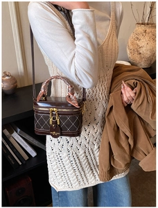 Detail of vintage brown box bag with quilted patterns and scarf-wrapped handle