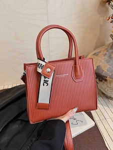 Brick red textured leather handbag with fashion strap and structured shoulder design